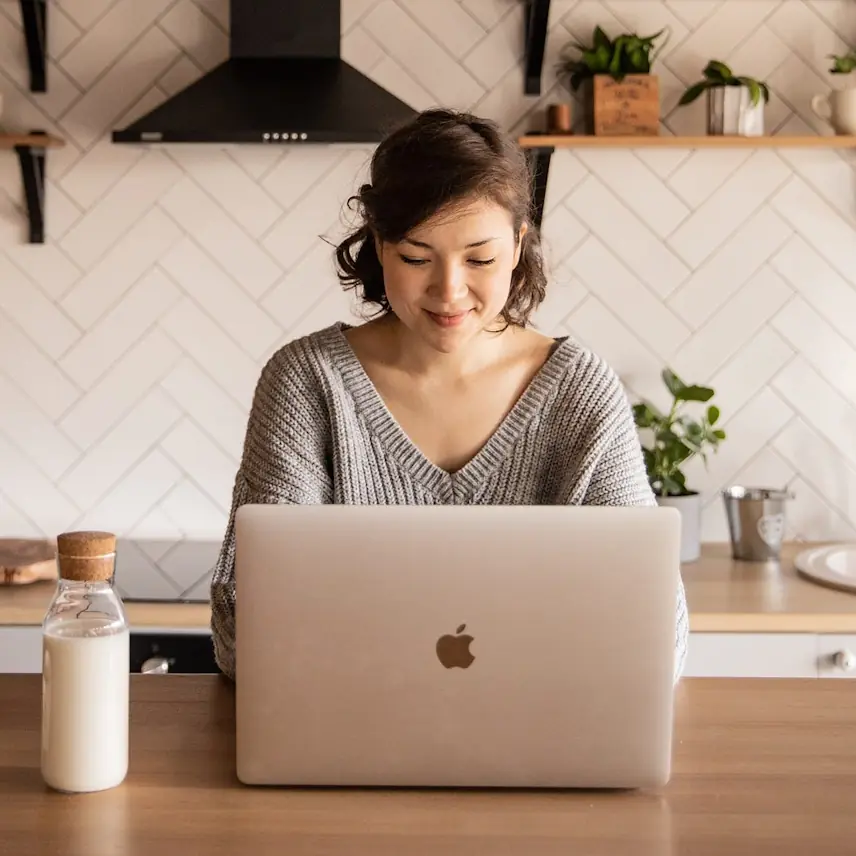 Woman sitting at table looking at her laptop